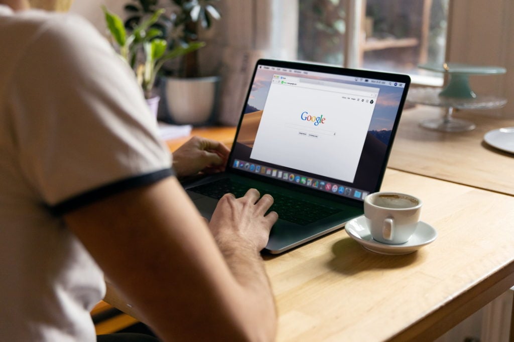 male browsing google page on their laptop